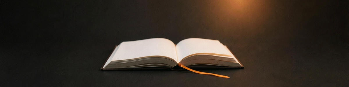 Photograph of an open blank book with an orange ribbon bookmark