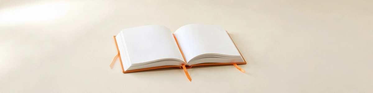 Photograph of an open blank book with an orange ribbon bookmark