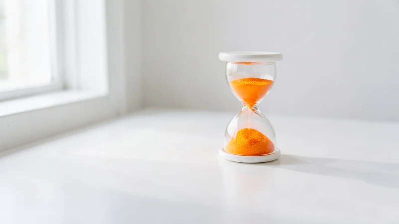 Photograph of a white hourglass filled with orange sand
