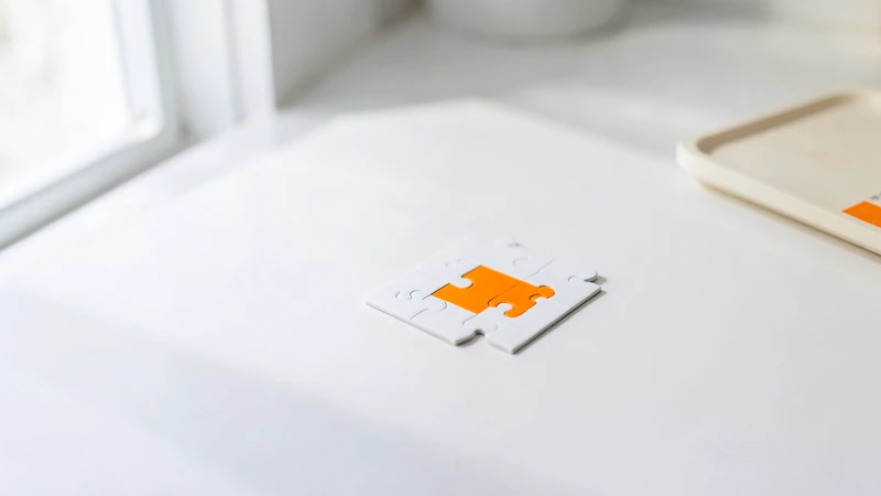 Photograph of a white four-piece puzzle with one orange piece